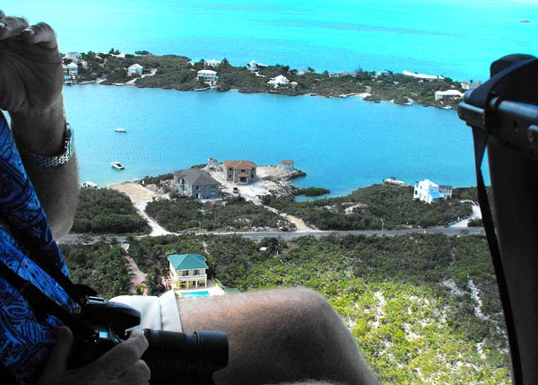 A photograph of a TCI Helicopters helicopter flying over Silly Creek, Providenciales (Provo), Turks and Caicos Islands
